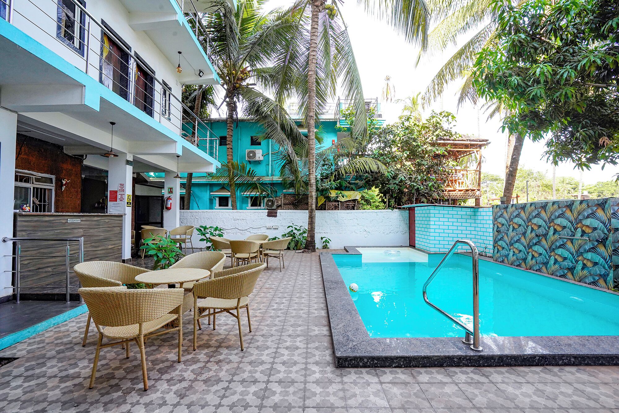A pool area with wicker furniture and a reception desk.