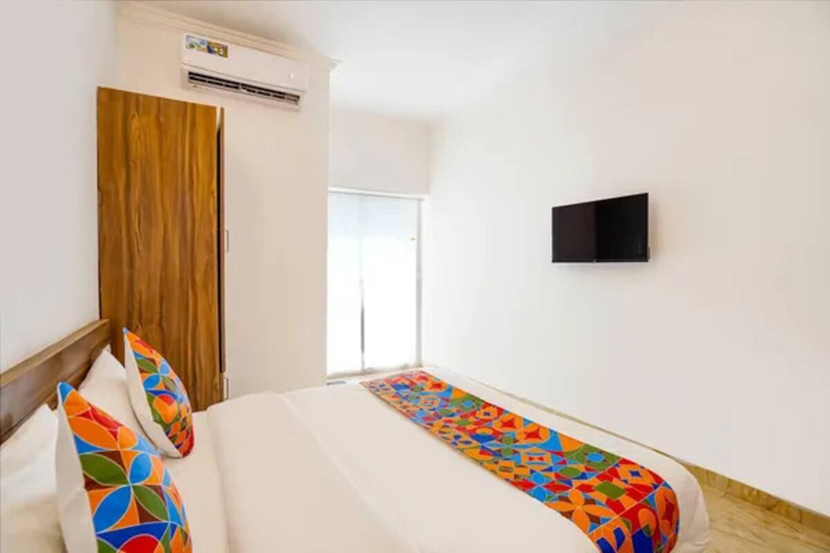 Ein Hotelzimmer mit Bett, Wand-Fernseher und Klimaanlage.