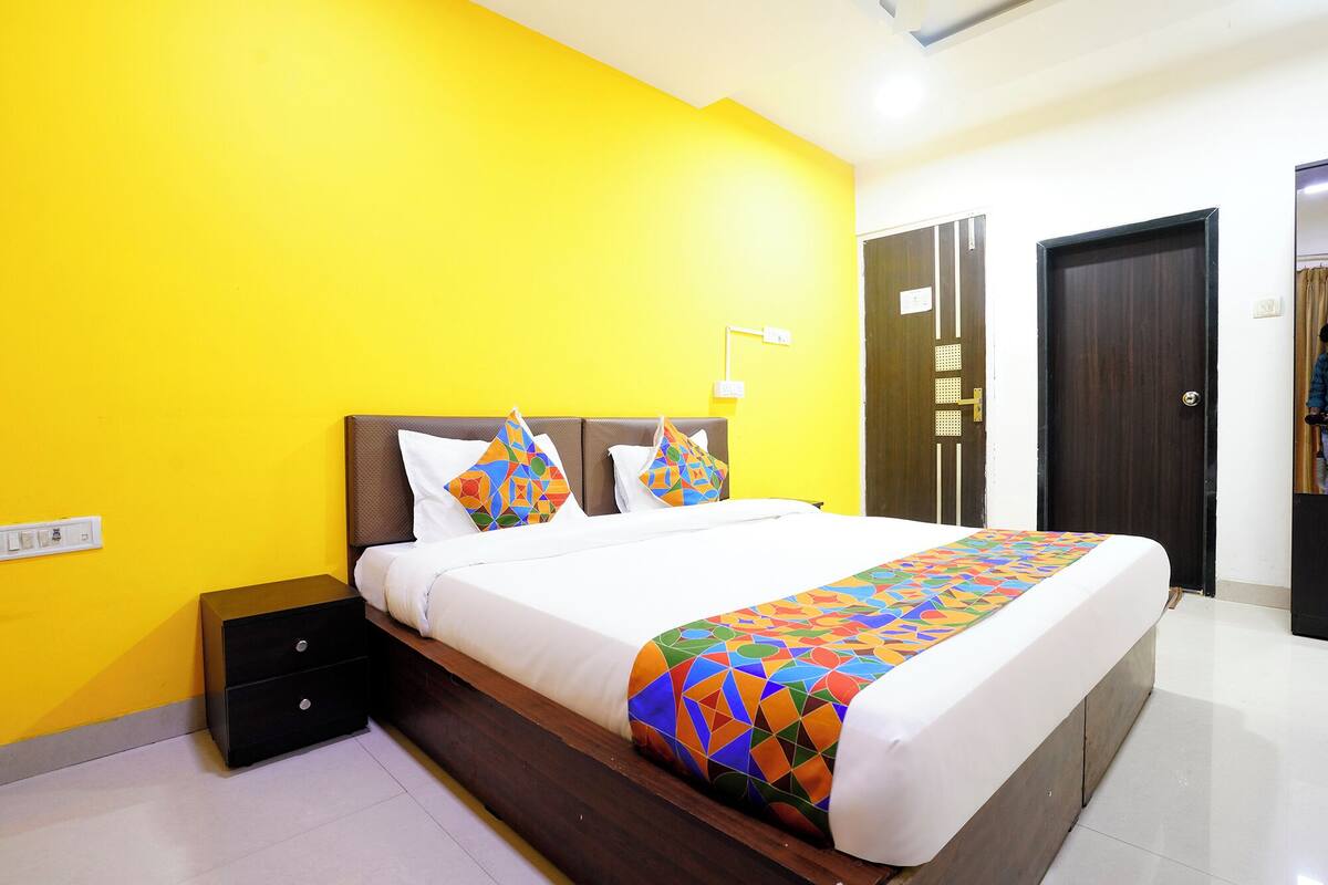 A hotel room with a bed, a nightstand, a wardrobe, and a door.