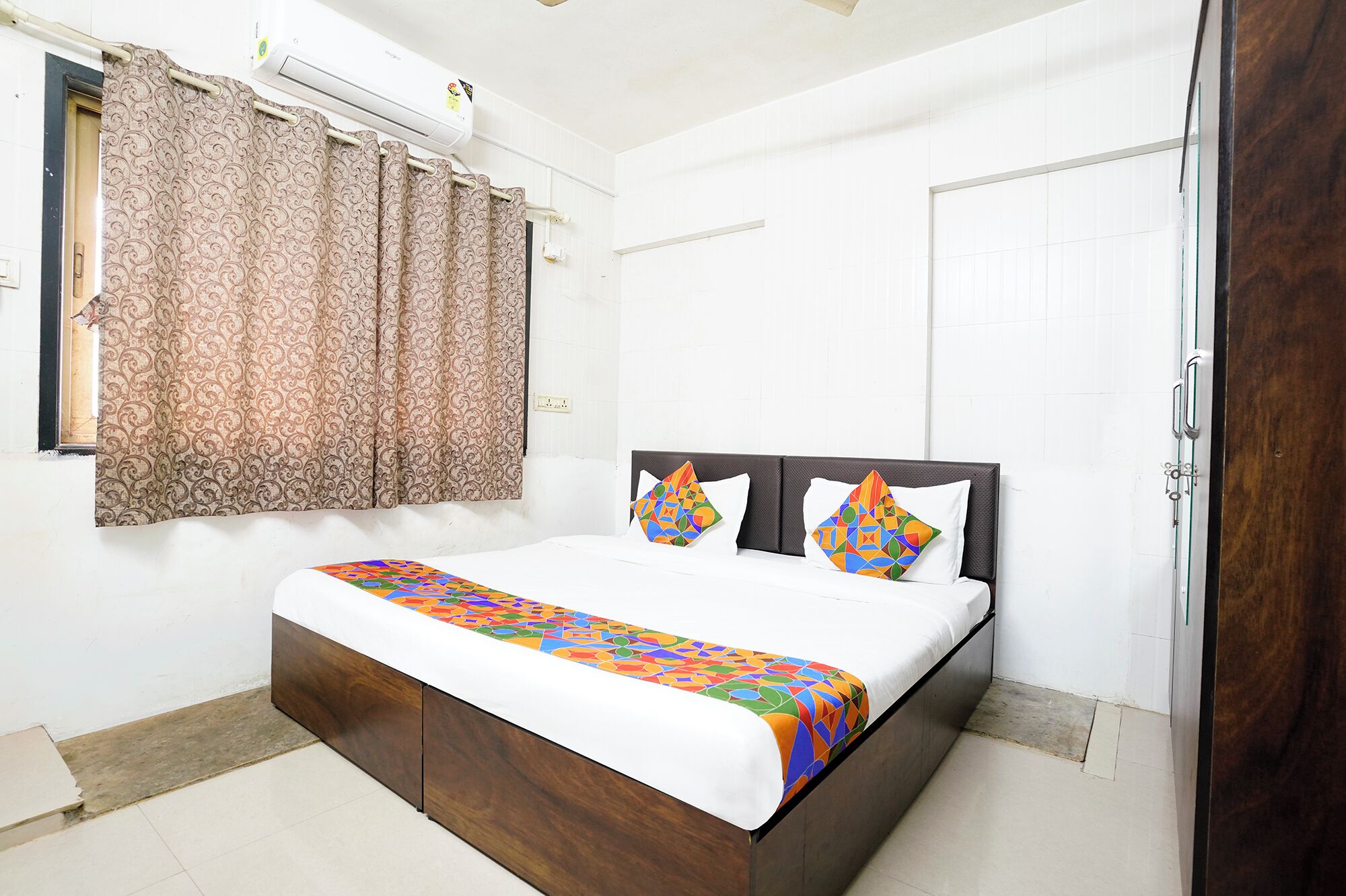 A bedroom with a bed, curtains, a door, and a window.
