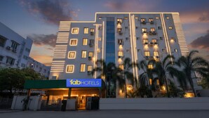 A modern hotel with a prominent facade, multiple balconies, and a well-lit entrance.