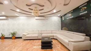 A modern lounge area with a curved sofa, a small coffee table, and a decorative ceiling light.