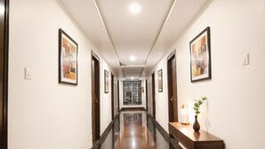 A long, narrow hallway with polished floors and framed artwork on the walls.