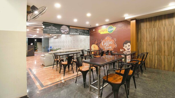 A hotel lobby with a reception desk, seating area, and a wall with a coffee-themed mural.