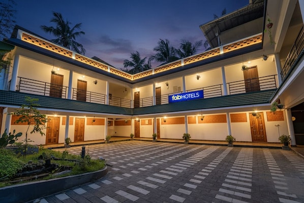 Een hotel met een centrale binnenplaats, meerdere balkons en een bordje met 'fab hotels'.