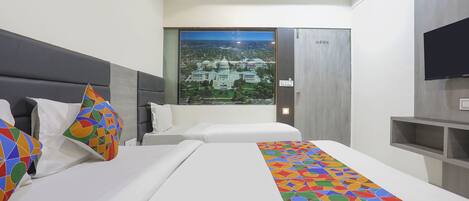 A hotel room with two beds, a large window with a cityscape view, a flat-screen TV, and a modern design.