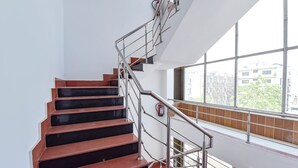A staircase with metal railings and a fire extinguisher on the wall. - Fabhotel Pearl (Haridwar)