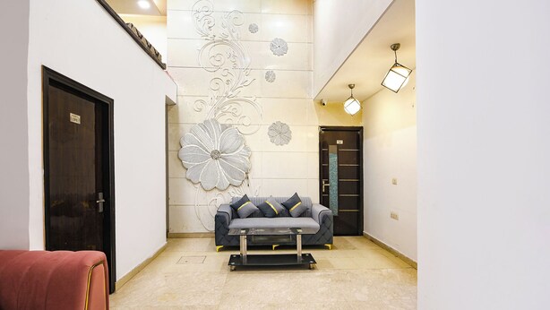 Een modern interieur met een bank, een rode stoel en decoratieve muurkunst.