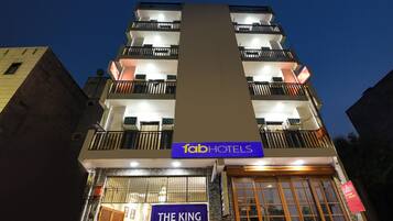 A multi-story building with a sign for 'fab hotels' and 'The King Residency A/C rooms'.