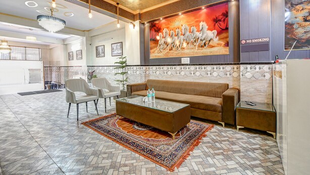 A spacious lobby with a high ceiling, a large wall mural, and a seating area with a coffee table and chairs. - Fabhotel The King Residency (New Delhi)