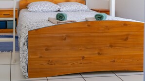 A bunk bed with a wooden frame and a lower bed with a floral bedspread.