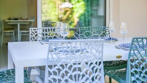 A dining area with white tables and chairs, set for a meal.