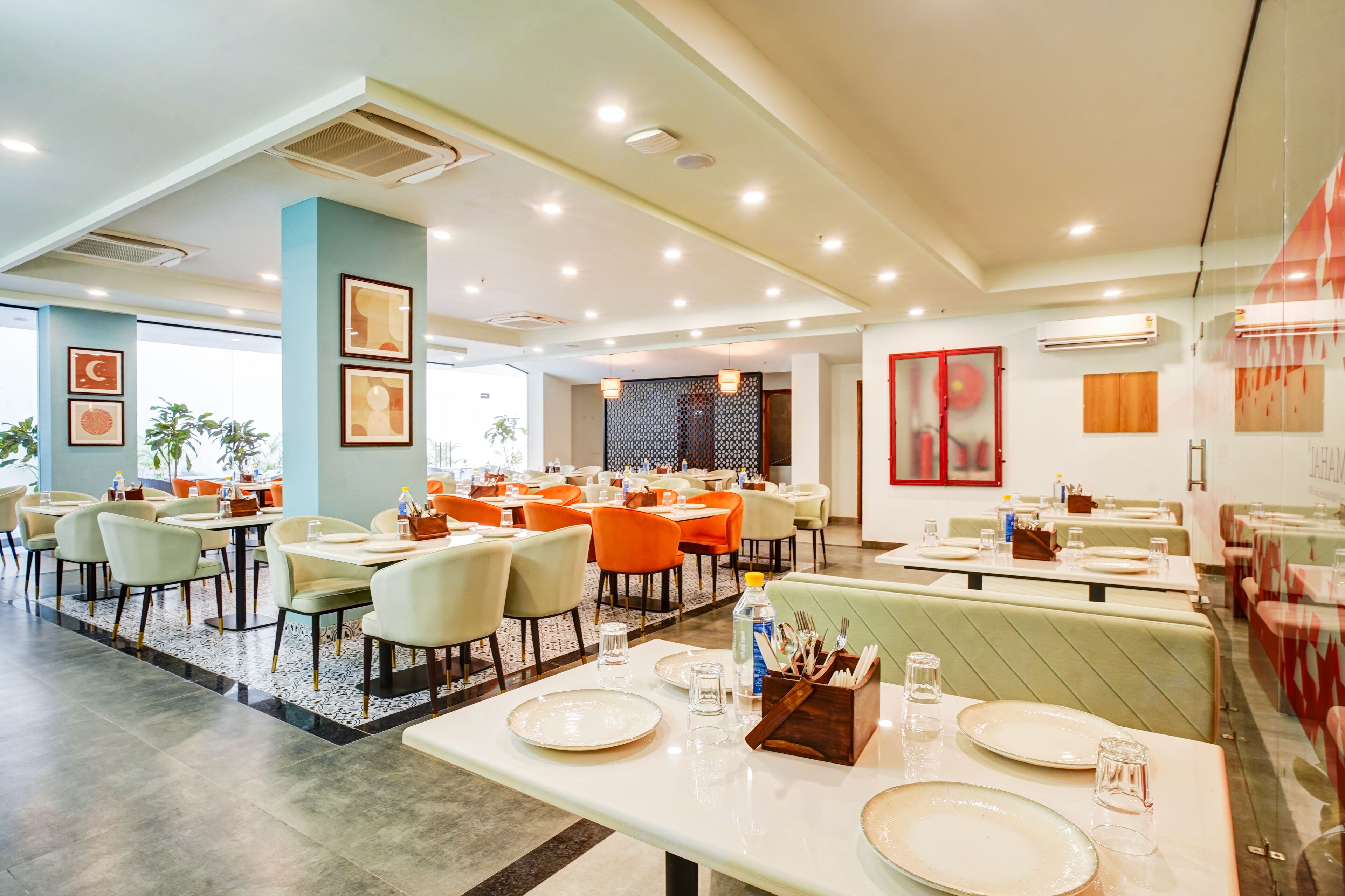 A modern restaurant with multiple dining areas, including booths and tables.