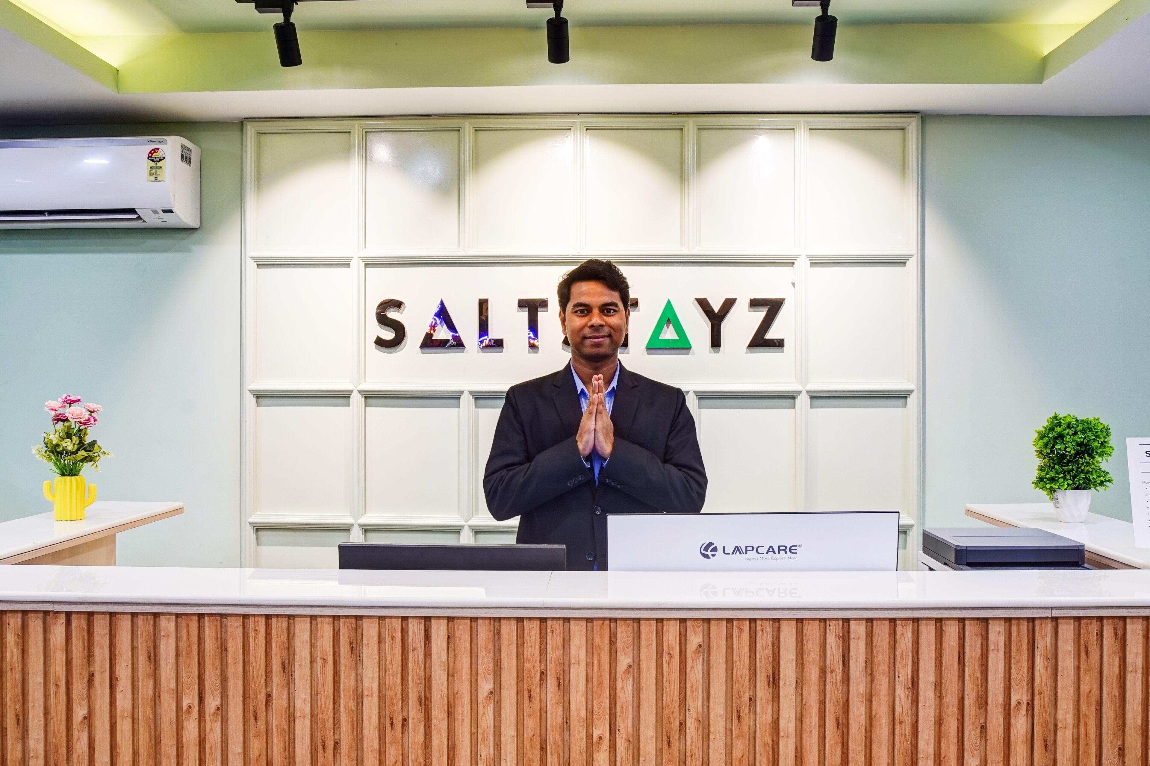A reception desk with a sign reading "SALTAYZ" and a logo "LAPCARE".