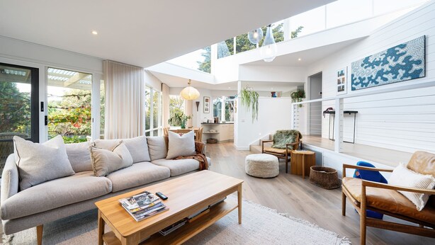 A spacious living room with a large sofa, coffee table, and a dining area. - Sky Views by Property Mums (Somers)