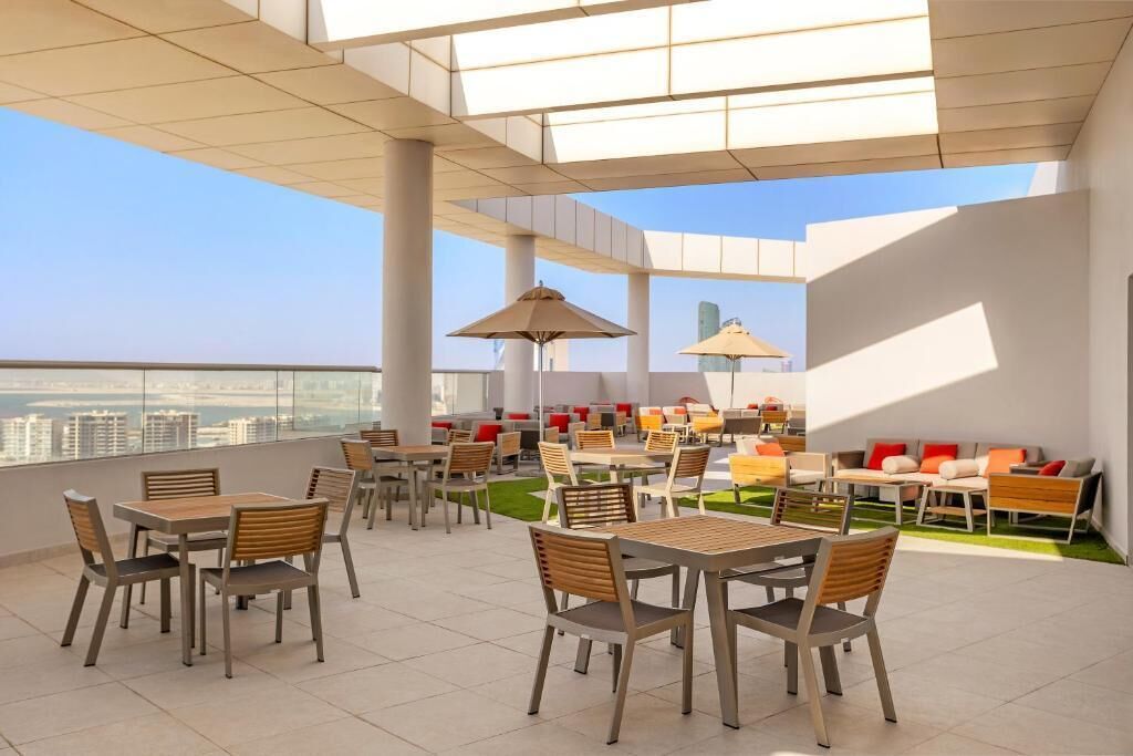 A rooftop terrace with outdoor seating, tables, and umbrellas.