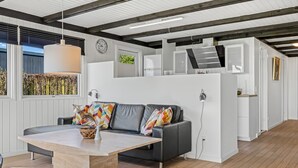 Un salon moderne avec un canapé, une table basse et un coin repas.