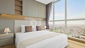 A modern hotel room with a large bed, nightstands, and a city view through large windows.