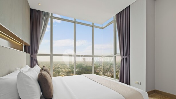 A modern hotel room with a large bed, a view of the city, and a large window with curtains. - Omira by Kozystay  - Cengkareng (Jakarta)