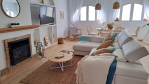 Ein modernes Wohnzimmer mit Kamin, Sofa und Fernseher.