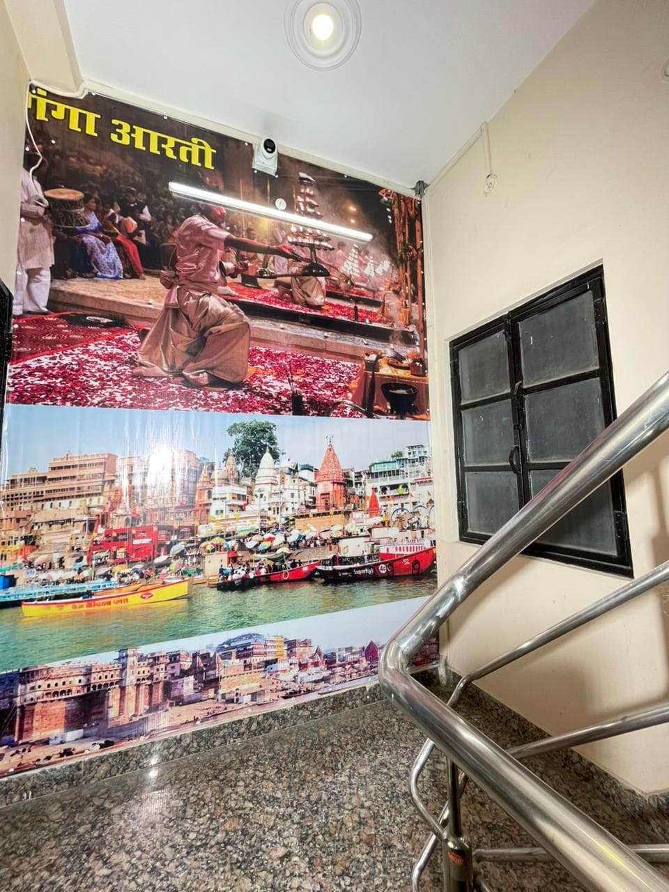 A staircase with a handrail, a poster with images of a river, boats, and buildings, and a window with blinds.