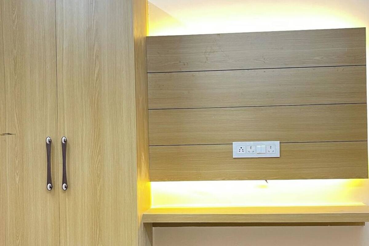 Un armario de madera con repisa iluminada y toma de corriente.