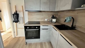 A compact kitchen with a Bosch oven, a coffee maker, and a sink.