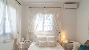 A bedroom with a bed, a nightstand, a lamp, and a chair. - Holiday Home Pozo Viejo (Marchena)