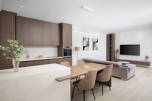 Una cucina moderna con zona pranzo, mobili a incasso, TV a schermo piatto e arredamento minimalista.