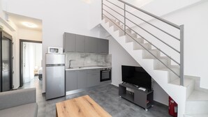 A modern kitchen with grey cabinets, a built-in oven, and a microwave. - Olympiada-Two Bedroom Loft No Pool Access (Kavala)