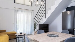 Una sala de estar moderna con un sofá, una mesa de comedor y una escalera.