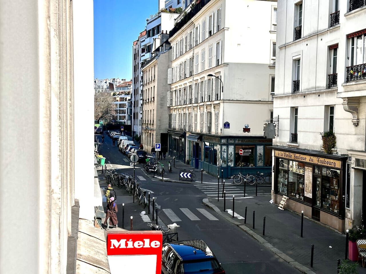 A street view with a building featuring a boutique store on the ground floor.