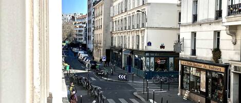 A street view with a building featuring a boutique store on the ground floor.