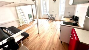 A compact room with a bunk bed, a small dining table, and a kitchenette. - Sunny Paris flat heart of 11ème (Paris)