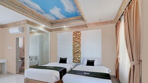 A hotel room with two beds, a bathroom, and a ceiling with a cloud design. - Hotel O My Home@Bali (Kuta)
