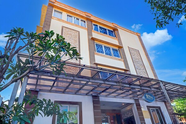 A multi-story building with a modern architectural design, featuring large windows and decorative elements on the facade. - Hotel O My Home@Bali (Kuta)