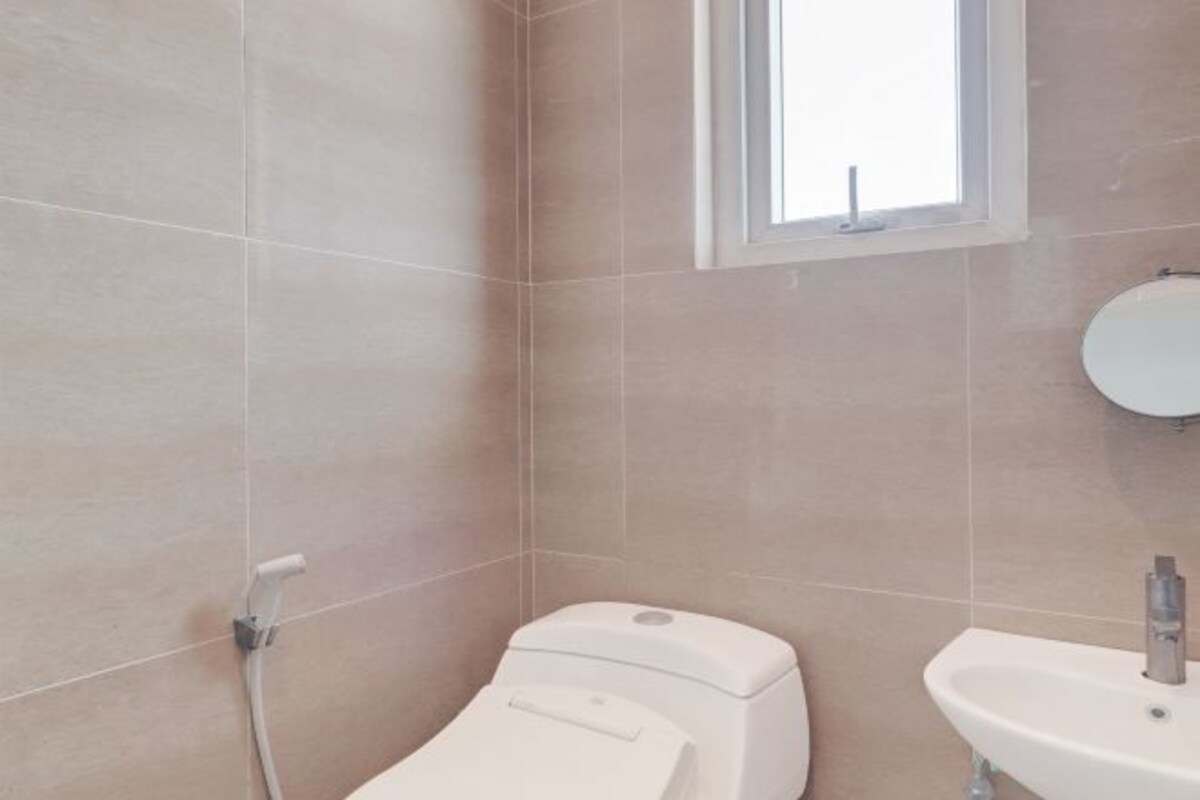 Un baño con inodoro, lavabo y ventana.