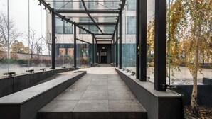 A covered walkway with glass panels, leading to a building entrance. - Apartamenty Sun & Snow Zamoyskiego (Warsaw)