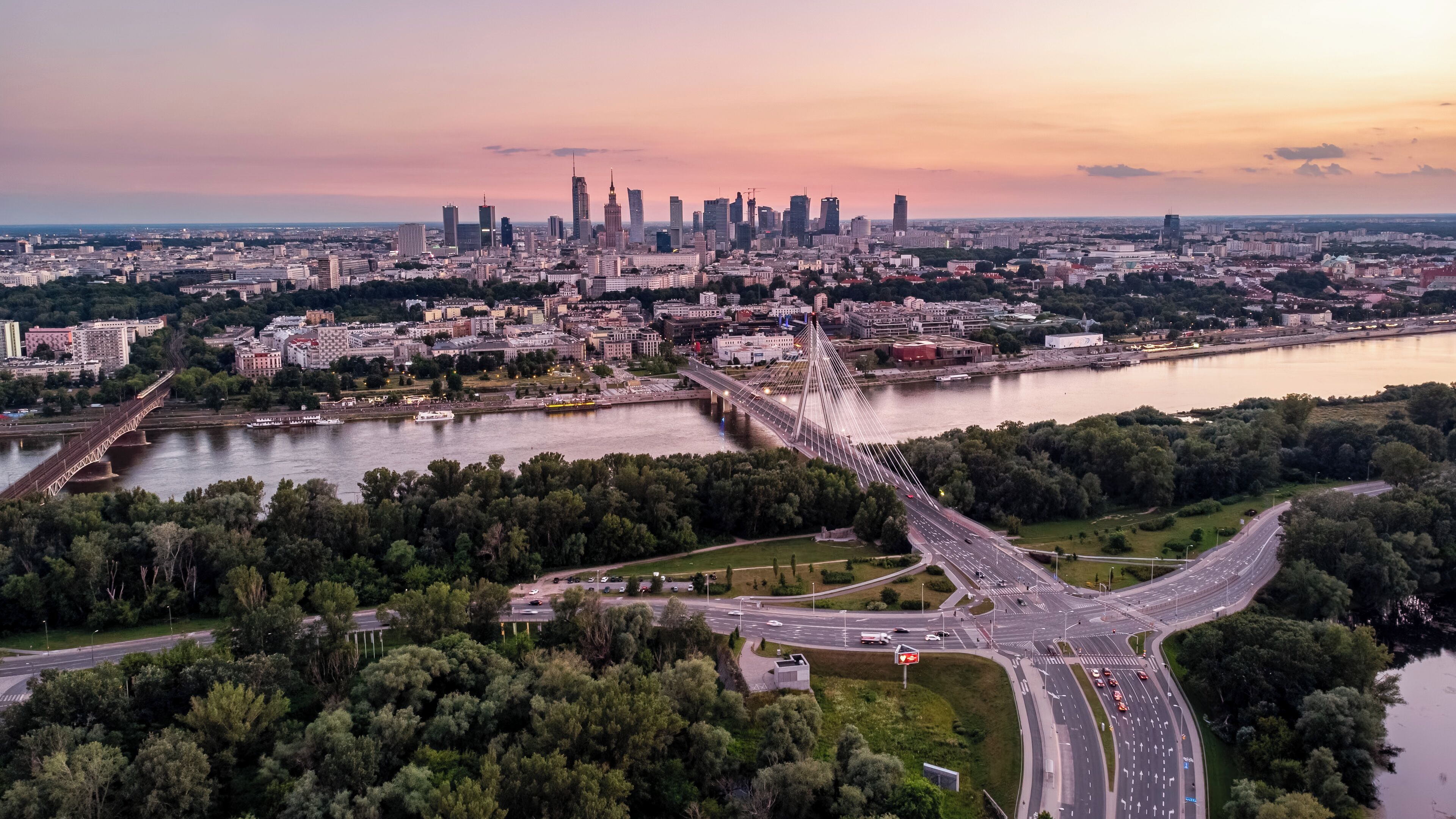 A cityscape with a prominent bridge, a river, and a dense urban skyline.
