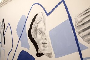 A wall with abstract art and a partial sculpture. - Garden Palace (Rome)