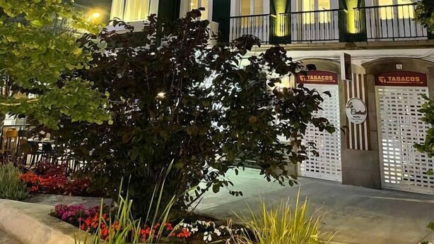Un edificio de varios pisos con balcones y un letrero que dice 'Tabacos'.