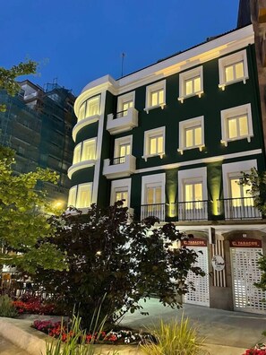 Un immeuble à plusieurs étages, doté de balcons et d’une enseigne indiquant « Tabacos ».