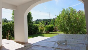 A covered outdoor dining area with a view of a lush garden and a clear sky. - 3-bedroom apartment in village Vinkuran (Vinkuran)