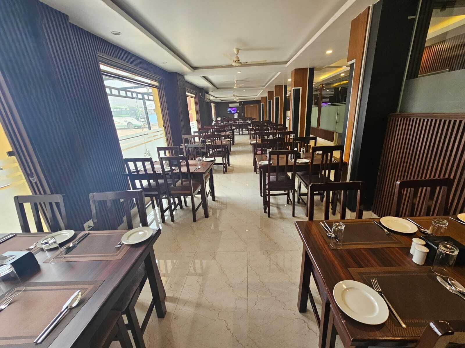 Un restaurant avec de nombreuses tables et chaises, disposées en rangées.