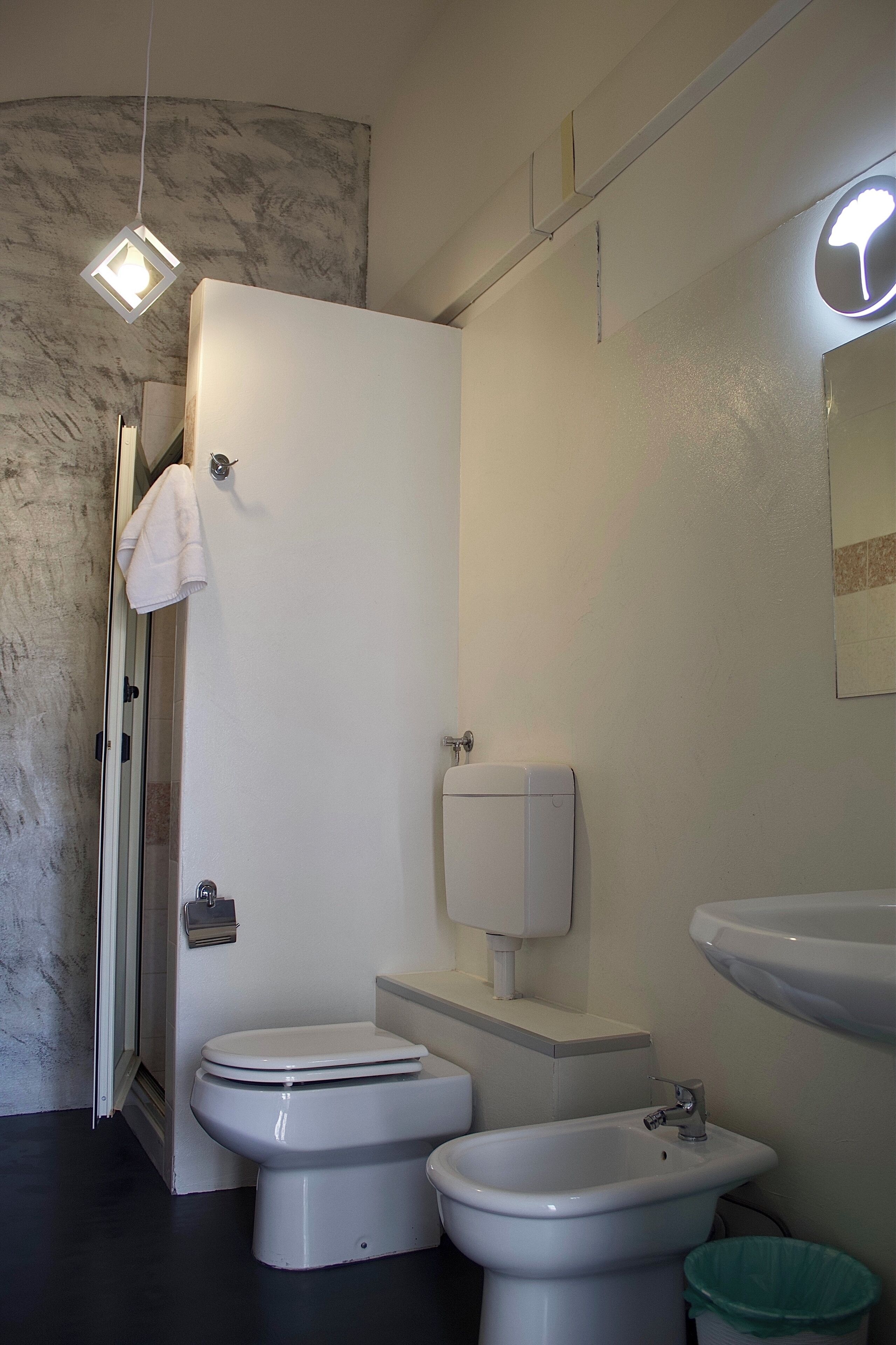 Un bagno moderno con il water, bidet, lavandino e porta asciugamani.