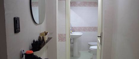 A narrow hallway leading to a bathroom with a sink and toilet.