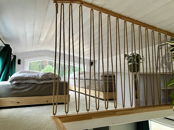 A room with a bed, a small table, and a hanging plant. - "Fuchs und Igel Tiny House" - Time out in the newly designed "Fuchs" Tiny House (Grünheide (Mark))