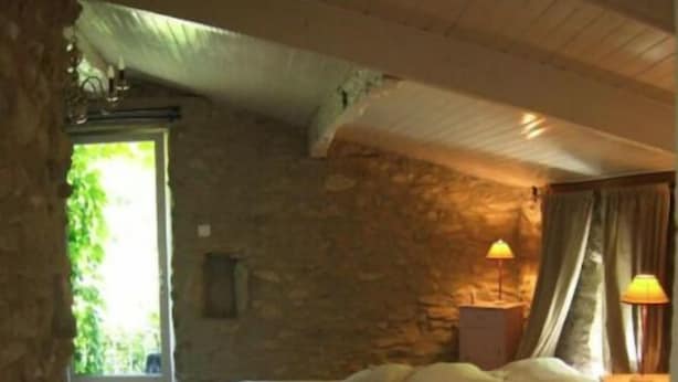 Una camera da letto con un letto, un tavolo e una sedia.