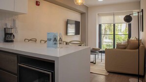 A modern kitchen with a coffee maker, a sign, and a bottle of water on the counter. - w* | Distinctive 1BR w/ Balcony in Barranco (Barranco)