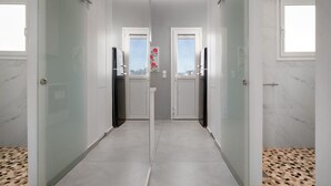A modern, narrow hallway with glass doors leading to individual rooms, each with a window and a door. - Jacuzzi Lux penthouse P Faliro (Paleo Faliro)